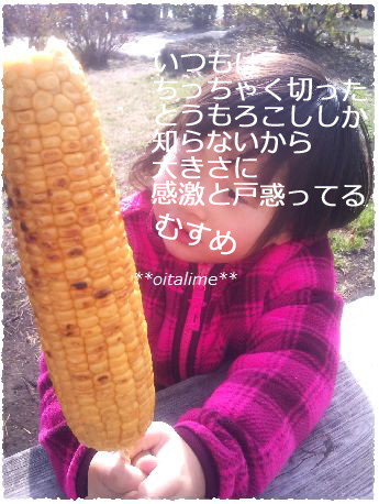 焼きトウモロコシを持った子どもの画像